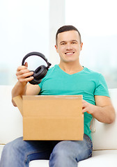 Image showing opening cardboard box and taking out headphones