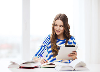 Image showing smiling student girl with tablet pc and books
