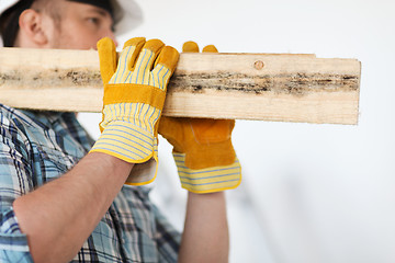 Image showing close up of male in gloves carrying wooden boards