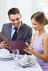 Image showing smiling couple with menu at restaurant