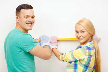 Image showing couple building using spirit level to measure
