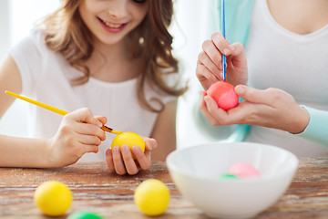 Image showing close up of little girl and mother coloring eggs