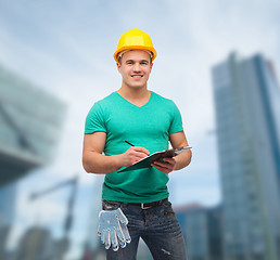 Image showing smiling man in helmet with clipboard