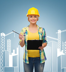 Image showing smiling woman in helmet with clipboard