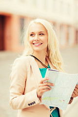 Image showing girl looking into tourist map in the city