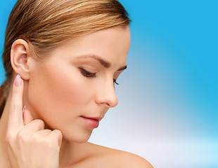 Image showing calm woman touching her ear