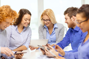 Image showing smiling team with table pc and papers working