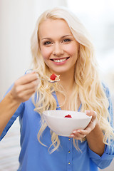 Image showing smiling woman with bowl of muesli having breakfast