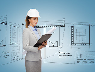 Image showing smiling architect in white helmet with blueprints