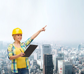 Image showing smiling woman in helmet with clipboard