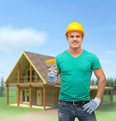 Image showing smiling manual worker in helmet with paintbrush