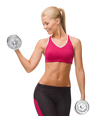 Image showing smiling woman lifting steel dumbbell