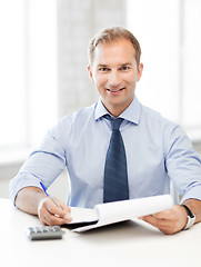 Image showing businessman with notebook and calculator