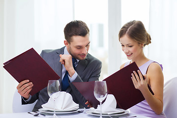 Image showing smiling couple with menus at restaurant