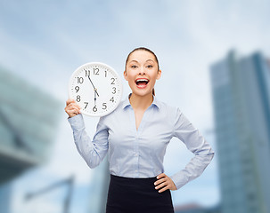 Image showing attractive businesswoman with wall clock