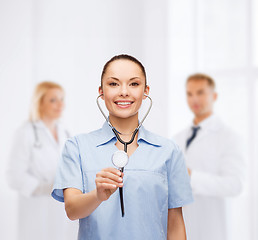 Image showing smiling female doctor or nurse with stethoscope