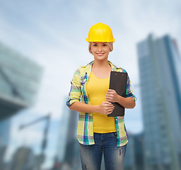 Image showing smiling woman in helmet with clipboard
