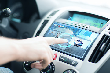 Image showing man using car control panel to read news