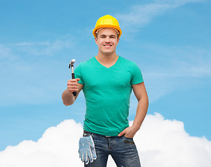 Image showing smiling manual worker in helmet with hammer