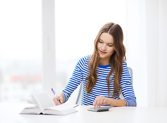 Image showing student girl with book, calculator and notebook