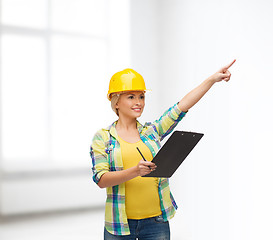 Image showing smiling woman in helmet with clipboard