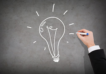 Image showing close up of businessman drawing light bulb