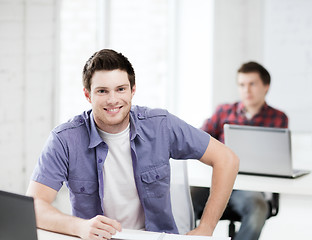 Image showing smiling student with laptop at school