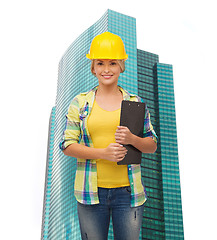 Image showing smiling woman in helmet with clipboard