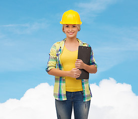 Image showing smiling woman in helmet with clipboard