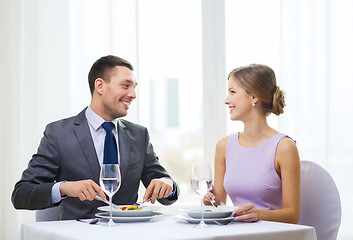 Image showing smiling couple eating appetizers at restaurant