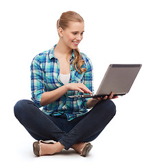 Image showing smiling woman with laptop sitting on floor