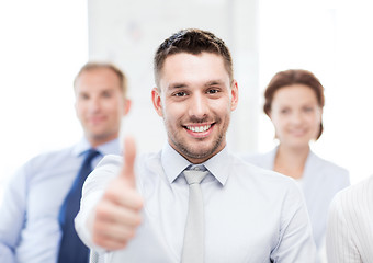 Image showing businessman in office showign thumbs up