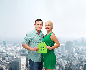 Image showing smiling couple holding green paper house