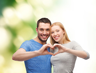 Image showing smiling couple showing heart with hands