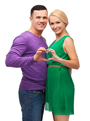Image showing smiling couple showing heart with hands