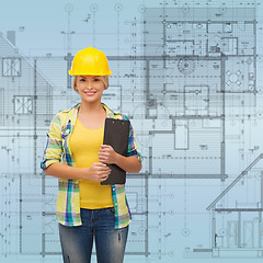 Image showing smiling woman in helmet with clipboard