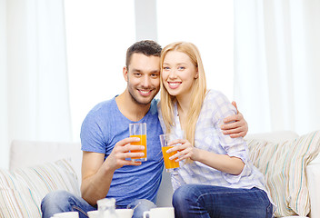 Image showing smiling happy couple at home drinking juice