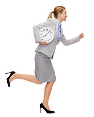 Image showing smiling young businesswoman with clock running