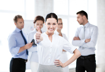 Image showing businesswoman in office showing thumbs up