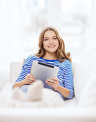 Image showing smiling teenage girl with tablet pc at home