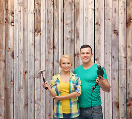 Image showing smiling couple with hammer and drill