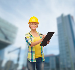 Image showing smiling woman in helmet with clipboard