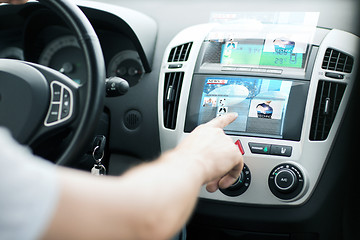 Image showing man using car control panel to read news