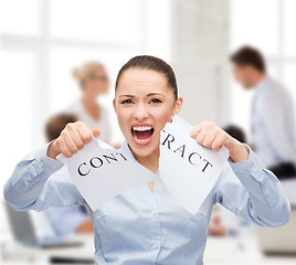 Image showing serious businesswoman tearing contract