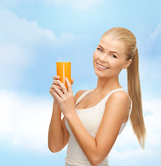 Image showing smiling woman holding glass of orange juice