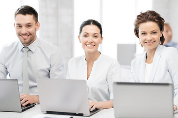 Image showing group of people working with laptops in office