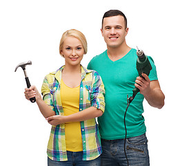 Image showing smiling couple with hammer and drill