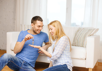 Image showing man giving keys to girlfriend or wife at home