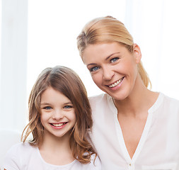 Image showing smiling mother and little girl with laptop at home