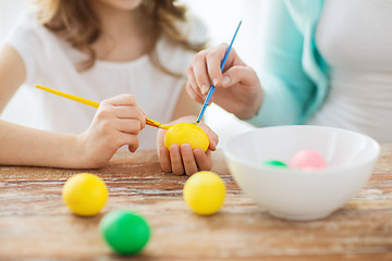 Image showing close up of little girl and mother coloring eggs